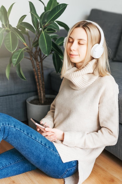 Young caucasian woman relaxes at home with music