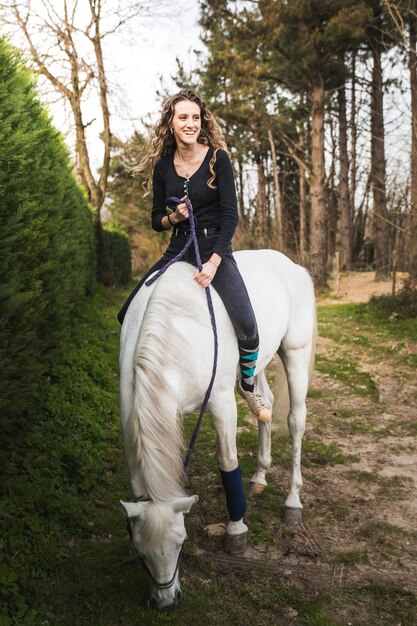 Young caucasian woman riding a horse in a horse centre