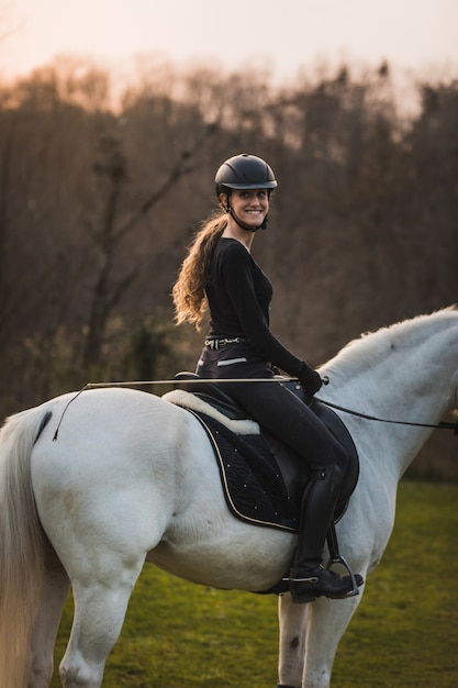 Young caucasian woman riding a horse in a horse centre