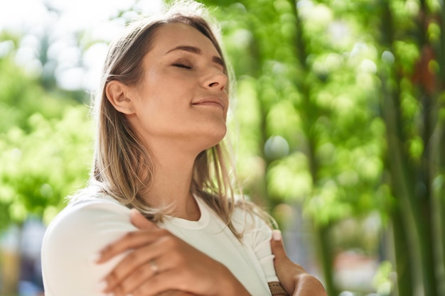 Young caucasian woman smiling confident breathing at park