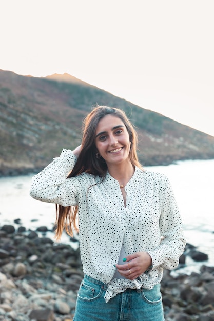 Young caucasian woman smiling wearing a white shirt at the beach