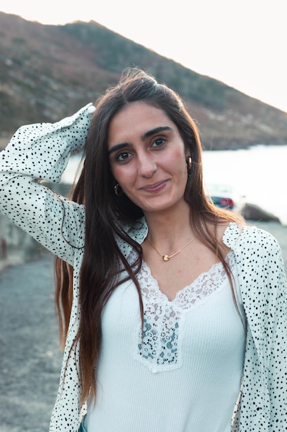 Young caucasian woman smiling wearing a white shirt at the beach