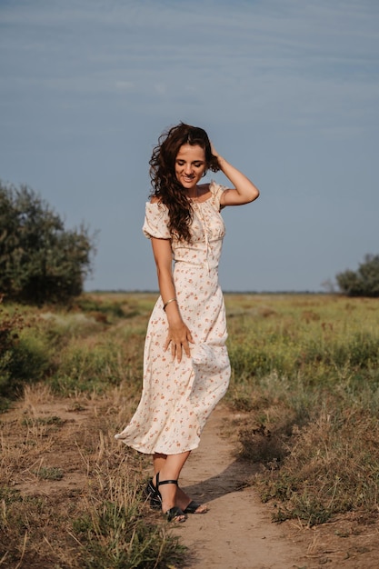 A young Caucasian woman strolling along a path in a picturesque steppe boundless landscape Autumn or summer