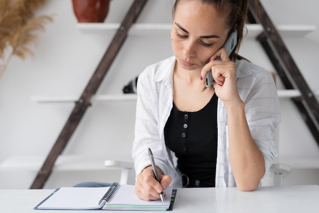 Young caucasian woman student or remote worker sitting at a desk at home in an office