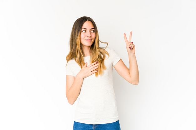 Young caucasian woman taking an oath, putting hand on chest.