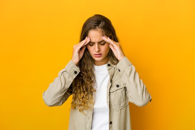 Young caucasian woman touching temples and having headache.