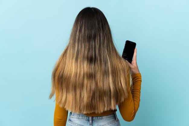 Young caucasian woman using mobile phone isolated