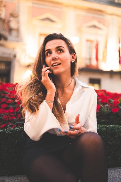 Young caucasian woman using a smartphone at night in Madrid, Spain.