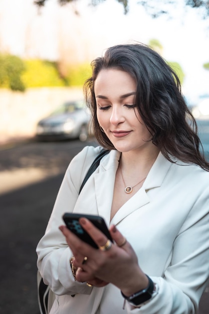 Young caucasian woman walking on the street using a smartphone