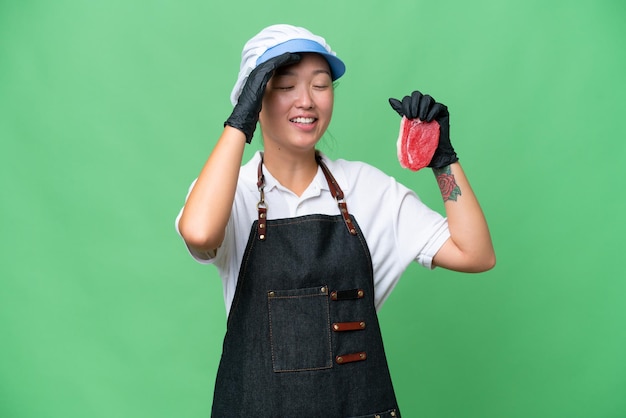 Young caucasian woman wearing an apron and serving fresh cut meat over isolated background smiling a lot