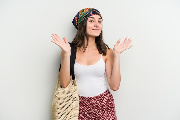 Young caucasian woman wearing a beach bag isolated on white background