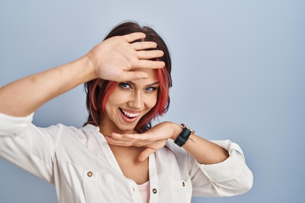 Young caucasian woman wearing casual white shirt over isolated background smiling cheerful playing peek a boo with hands showing face. surprised and exited