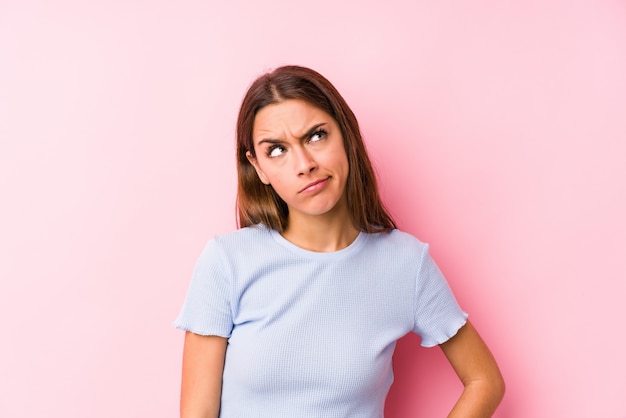 Young caucasian woman wearing a ski clothes confused, feels doubtful and unsure.