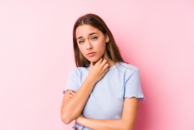 Young caucasian woman wearing a ski clothes isolated suffers pain in throat due a virus or infection.