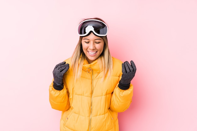 Photo young caucasian woman wearing a ski clothes in a pink background joyful laughing a lot. happiness concept.