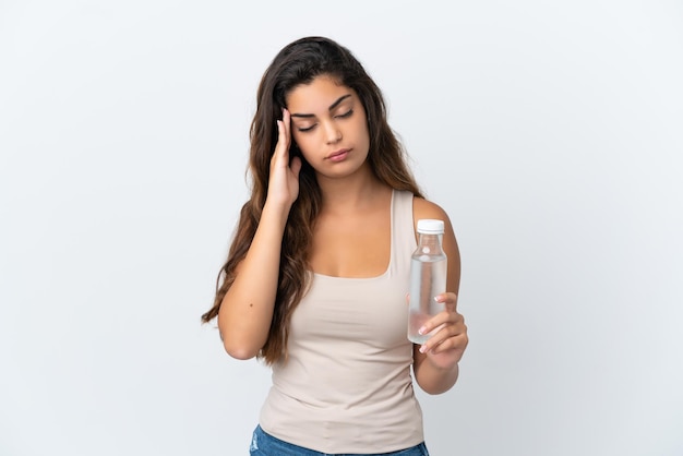 Young caucasian woman with a bottle of water isolated on white background with headache