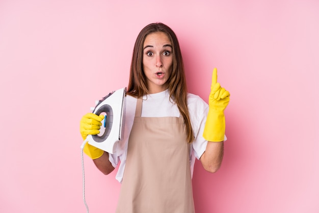 Young caucasian woman with clothes iron isolated having some great idea, concept of creativity.