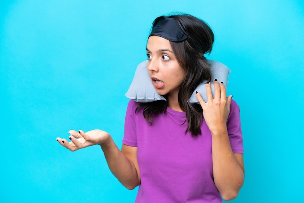 Young caucasian woman with Inflatable Travel Pillow isolated on blue background with surprise facial expression