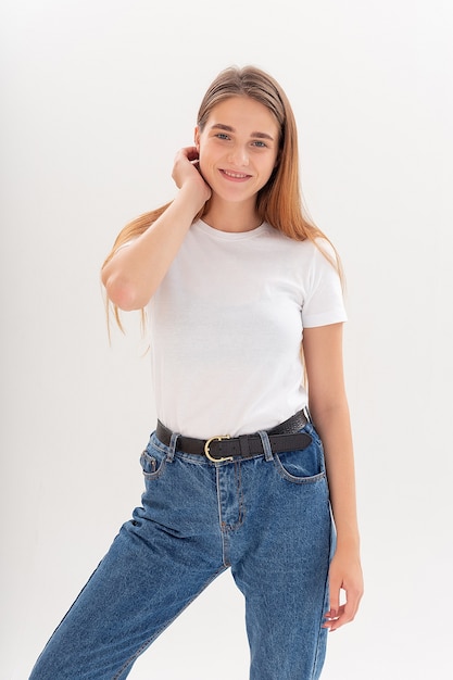 Young caucasian woman with long hair in t-shirt and blue jeans isolated on white