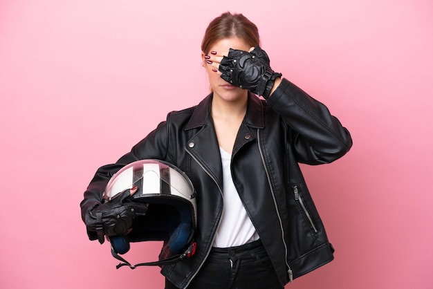 Young caucasian woman with a motorcycle helmet isolated on pink background covering eyes by hands Do not want to see something