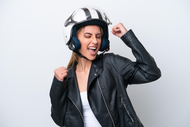 Young caucasian woman with a motorcycle helmet isolated on white background celebrating a victory