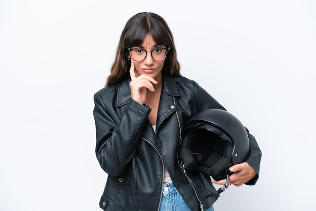 Young caucasian woman with a motorcycle helmet isolated on white background thinking