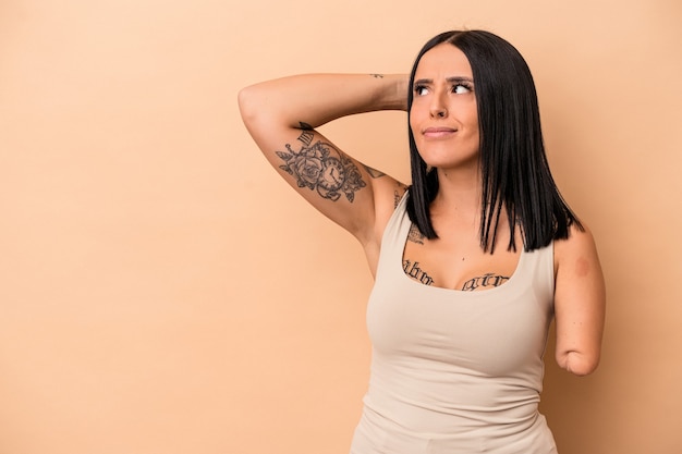 Photo young caucasian woman with one arm isolated on beige background touching back of head, thinking and making a choice.