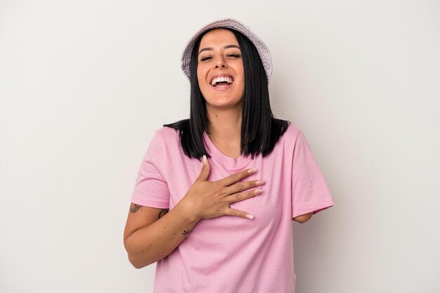 Young caucasian woman with one arm isolated on white background laughs out loudly keeping hand on chest.