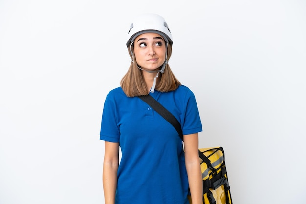 Young caucasian woman with thermal backpack isolated on white background and looking up