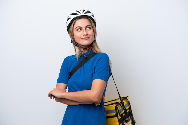 Young caucasian woman with thermal backpack isolated on white background with arms crossed and happy