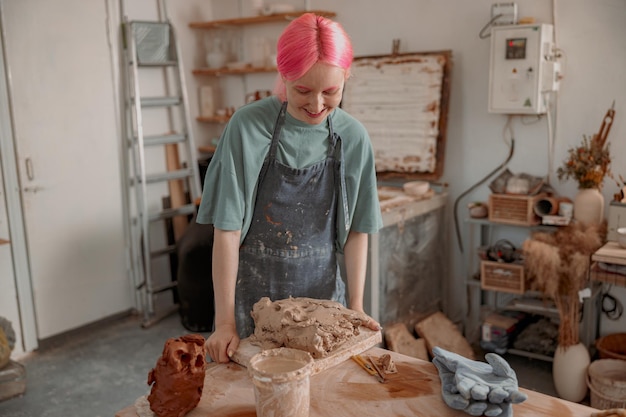 Young ceramist working with clay in workroom