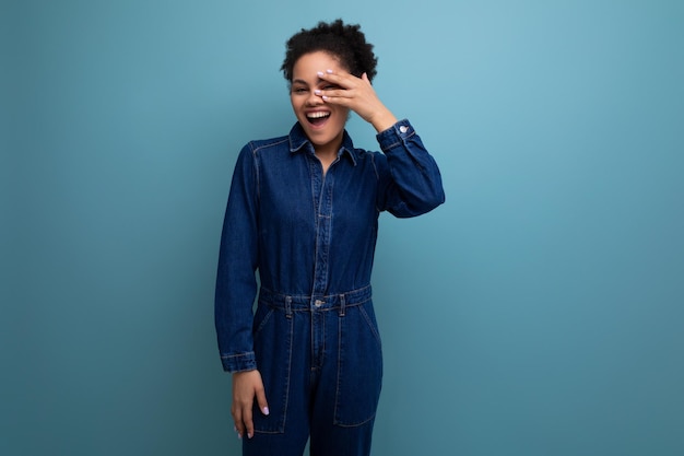 Young charming brunette latin woman in blue denim suit over isolated background