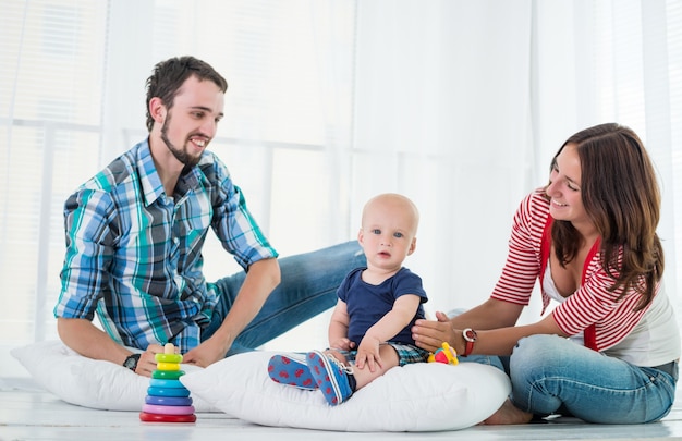 Young charming family mom dad and son play together sitting in the living room on a day off. Happy young family concept