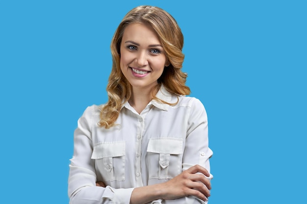 Young charming office lady posing at camera on blue background