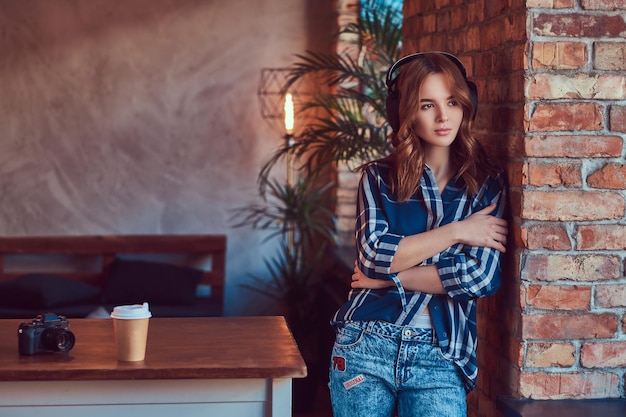 A young charming sensual girl listening to a music in headphones