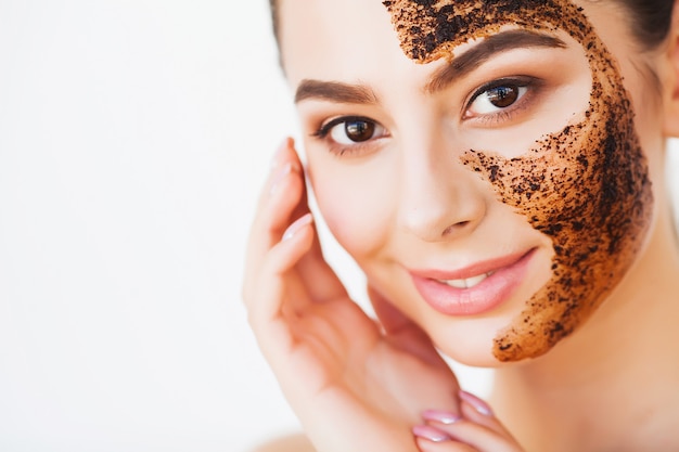 Young charming woman Makes a Black Charcoal Mask on Her Face