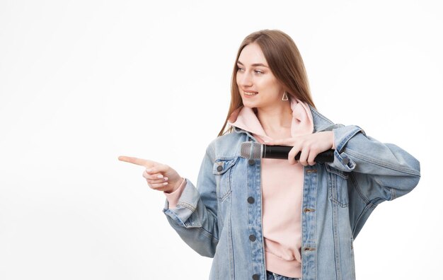 Young cheerful caucasian woman holding microphone isolated on white background and show space for your text