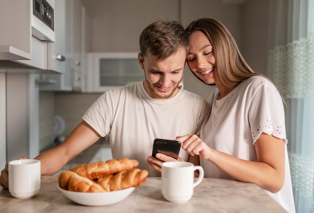 Young cheerful couple using smartphone during