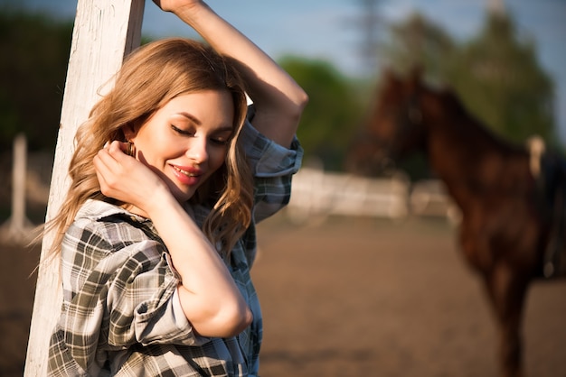 Young cheerful girl with her favorite horse.