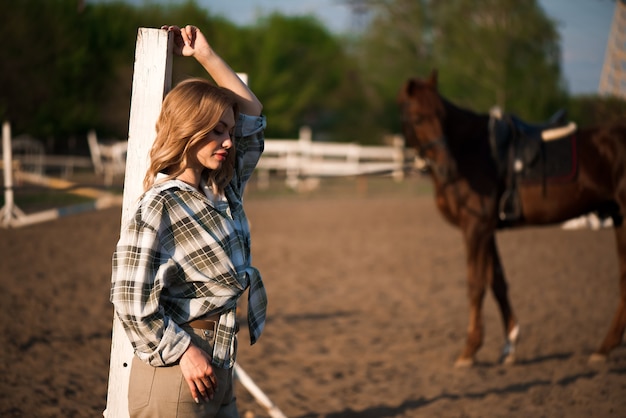 Young cheerful girl with her favorite horse.