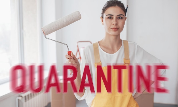 Young cheerful woman with paint wheel in work uniform at home at quarantine time