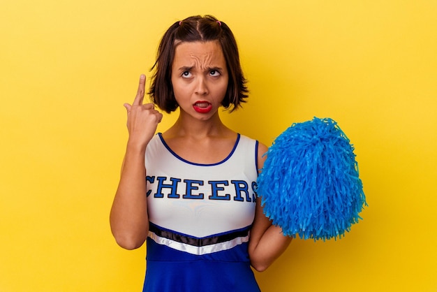 Photo young cheerleader mixed race woman isolated on yellow background showing a disappointment gesture with forefinger.