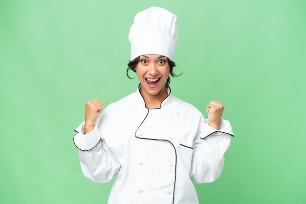 Young chef Argentinian woman over isolated background celebrating a victory in winner position