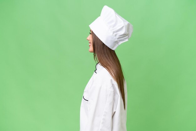 Young chef caucasian woman over isolated background laughing in lateral position