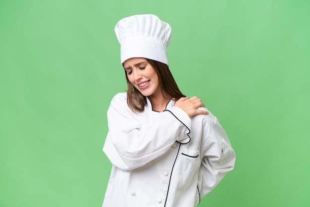 Young chef caucasian woman over isolated background suffering from pain in shoulder for having made an effort