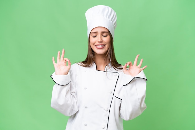 Young chef caucasian woman over isolated background in zen pose