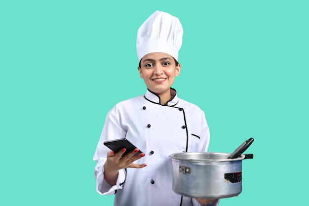 young chef girl white outfit holding pan and smart phone indian pakistani model