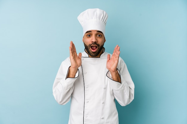 Young chef man looking shocked