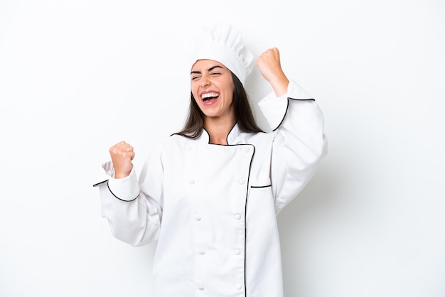 Young chef woman over white background celebrating a victory