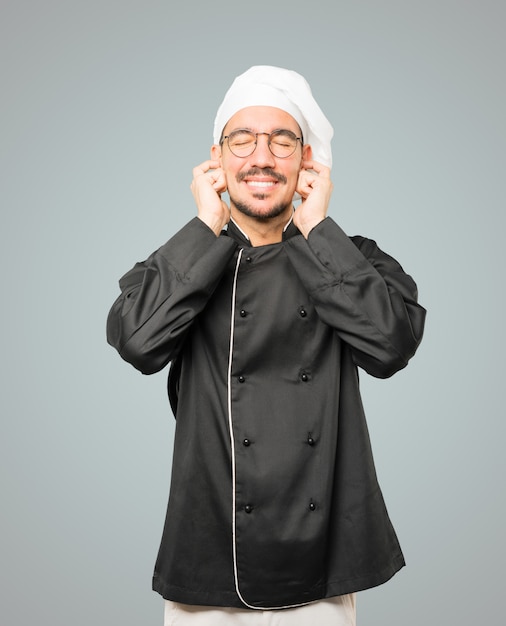 Young chef worried about loud noises and covering his ears